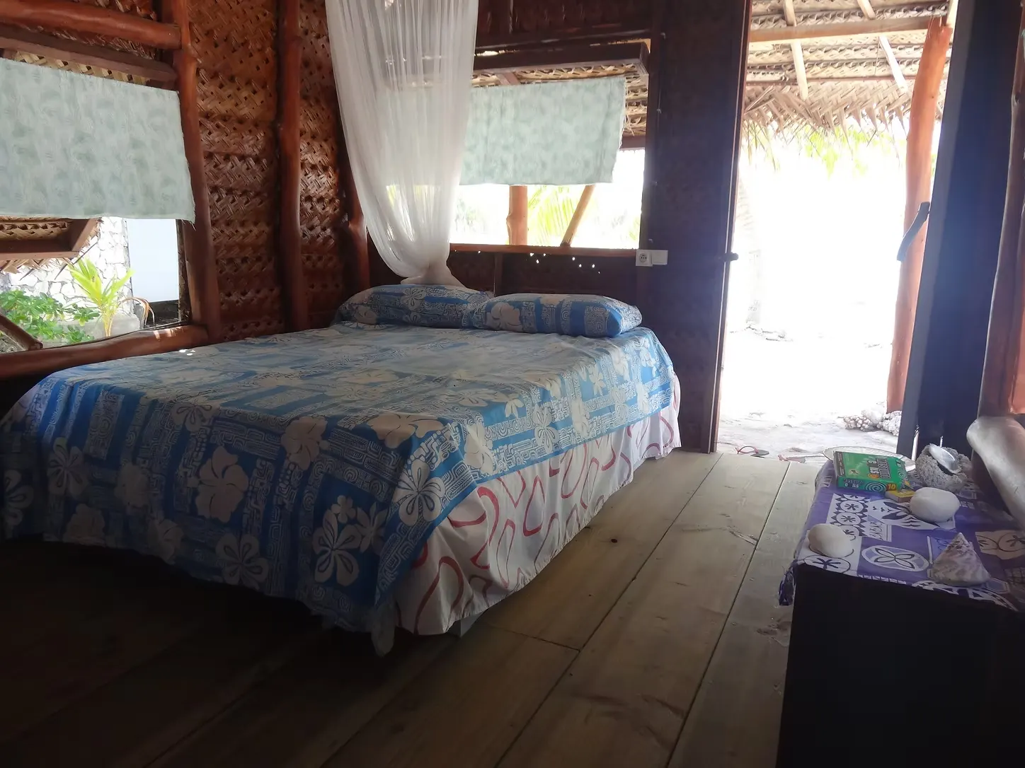 Le lit double et sa moustiquaire, sous le toit tressé
