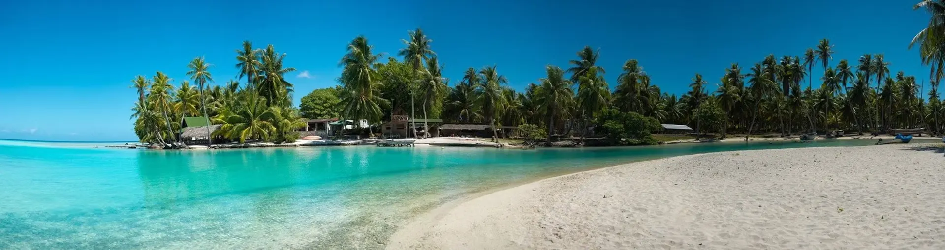La plage de sable blanc de la pension sur le motu
